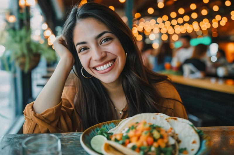 smiling woman about to eat a taco