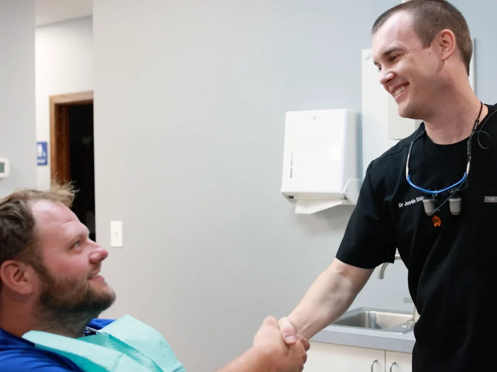 Dr. Shirk shaking hands with a smiling patient | Dentist in Lincoln, NE